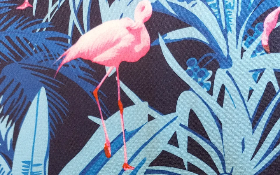 Pink flamingos and blue foliage printed on dark fabric